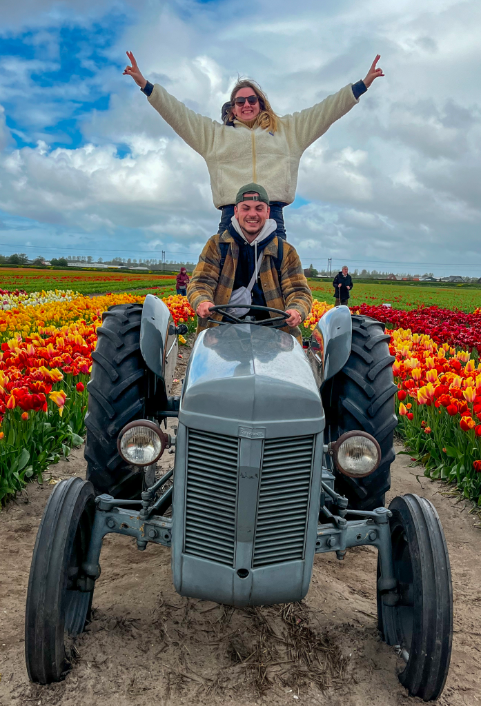 Eloïse et Jules debout à côté d'un ancien tracteur dans un jardin hollandais.