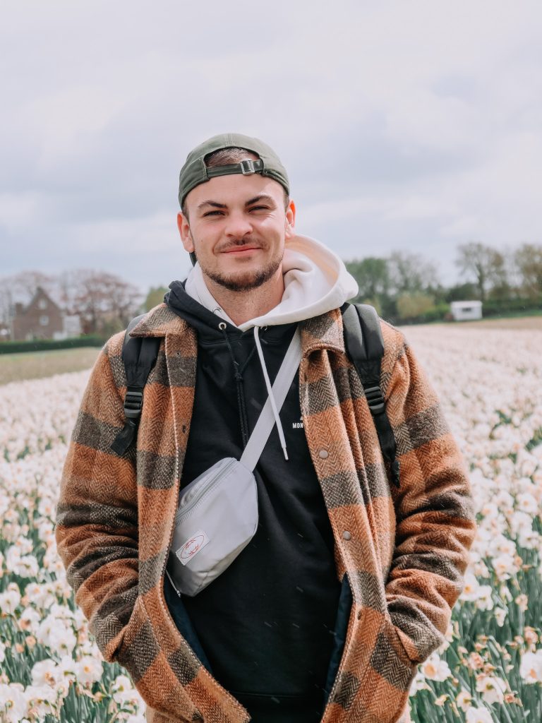 Jules posant dans un champ de tulipes multicolores, sourire aux lèvres