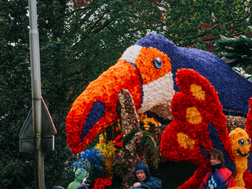 Sculpture florale colorée, représentant un oiseau exotique au carnaval.