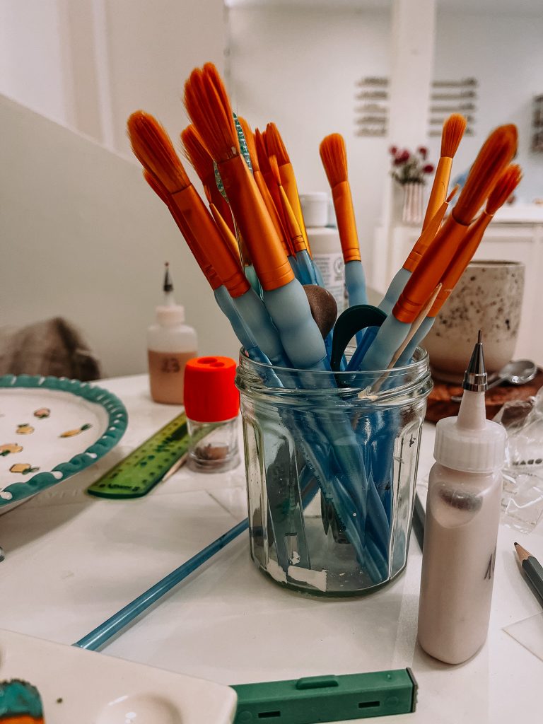 Atelier du Art Café Céramique à Rennes, avec étagères et créations exposées.
